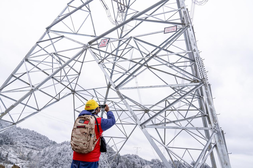 2月9日，在彭水縣中嶺山，國網(wǎng)重慶電力員工對電力線路開展冰雪特巡。牟偉攝